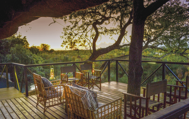 Kaza Safari Lodge, Aussen, Terrasse, Bäume, Sonnenuntergang, Stühle, Holz - 593612©Kevin Hogan